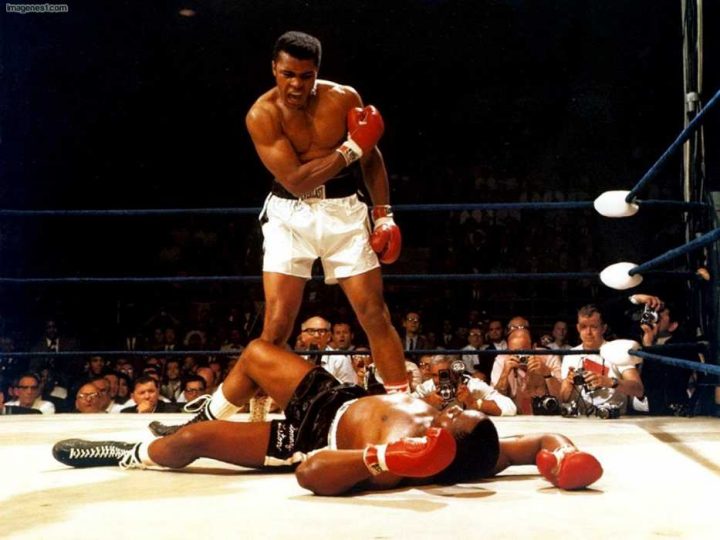 Muhammad Ali knocks down his opponent in the ring.